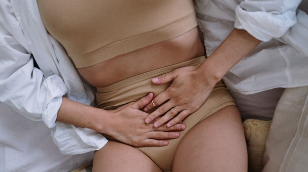 close-on-woman-holding-her-belly-in-pain-What-is-Period-Fatigue-What-Are-the-Causes-px