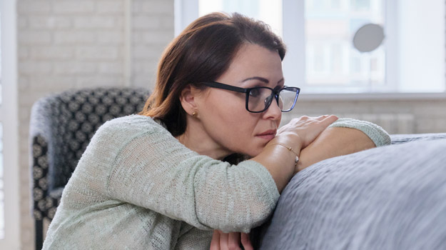 middle-aged-woman-with-glasses-looking-tired-Is-Period-Fatigue-a-Menopause-Symptom-ss