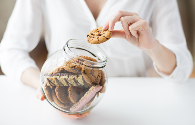 close-up-of-hands-with-sweets-in-jar-10-Signs-of-An-Unhealthy-Gut-7-Sweet-Cravings